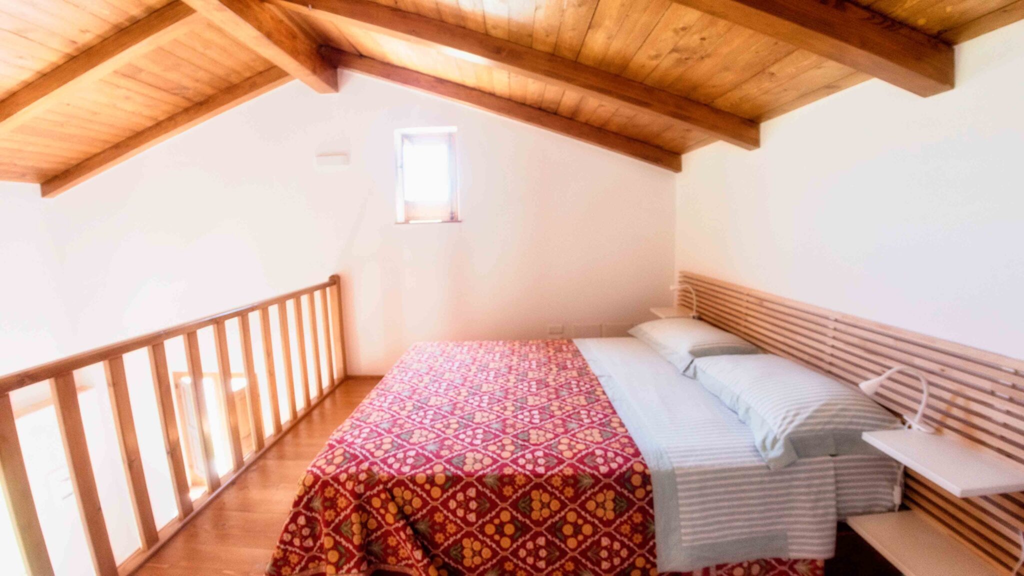 foto del letto matrimoniale sul soppalco della casa del mandarino di borgo carbone